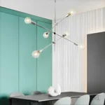 Luminaria Saku Platinium sobre comedor moderno con sillas rojas.