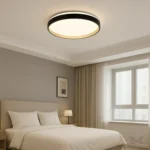 Luminaria Diane Black and Gold instalada en dormitorio minimalista. Su diseño plano y elegante se integra sin esfuerzo con la decoración, aportando luz uniforme y un ambiente acogedor. Ideal para crear una atmósfera moderna con estilo discreto.