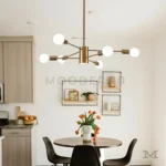 Luminaria Daphne Gold instalada sobre un comedor moderno.