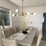 Luminaria Daphne sobre una mesa de comedor rectangular.