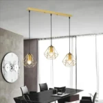 Luminaria Regina Gold iluminando un comedor moderno.