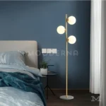 Lámpara Darla junto a una cama en habitación moderna.