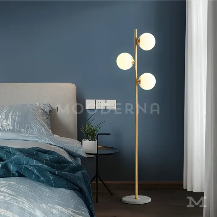 Lámpara Darla junto a una cama en habitación moderna.