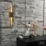 Ambiente moderno con pared clara y Luminaria Amanda Gold iluminando lateralmente.