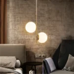 Luminaria Lucy Gold junto a cama en dormitorio decorado.