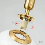 Vista cercana de la luminaria Daysi Black and Gold mostrando los detalles del foco y el acabado satinado. El contraste del dorado con el negro refleja calidad y elegancia, ideal para fotografías de producto o enfoque en materiales premium.