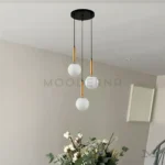 Luminaria Daysi Black and Gold en comedor con acabado dorado brillante. El diseño vertical realza la altura del ambiente y crea una atmósfera acogedora. Su luz LED cálida mejora la estética del mobiliario y da una sensación de amplitud.