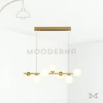 Luminaria dorada colgante con esferas blancas sobre fondo blanco