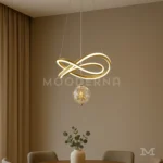 Luminaria Calix Gold instalada sobre comedor contemporáneo. Su diseño curvado crea un efecto visual sofisticado mientras su luz LED de 60W ilumina de forma uniforme el área de la mesa. Ideal para quienes buscan un detalle moderno con elegancia dorada.