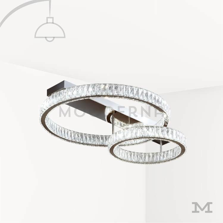 Annelie Platinum luminaria moderna cromada. Luminaria Annelie Platinum sobre fondo blanco con acabado cromado brillante y doble aro suspendido. Su diseño moderno incorpora luz LED integrada que ilumina de forma uniforme, ideal para espacios elegantes y contemporáneos.