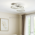 Luminaria Annelie Platinum instalada en una sala moderna, iluminando el ambiente con un acabado cromado reflectante que aporta sofisticación. Sus aros LED generan una iluminación uniforme ideal para espacios minimalistas y elegantes.