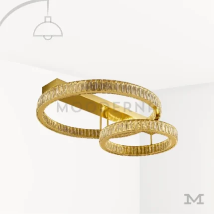 Luminaria Annelie Gold en fondo blanco con doble aro en acabado dorado brillante y luz LED integrada. Diseño moderno y elegante, ideal para iluminar salas y dormitorios con un estilo sofisticado.