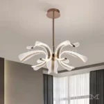 Luminaria Thea Gold instalada en comedor elegante. Su luz LED blanca cálida ilumina suavemente la mesa principal, aportando un ambiente acogedor y refinado. Ideal para hogares con estilo moderno y detalles dorados.