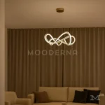 Luminaria Farella Gold instalada sobre sala amplia con acabados contemporáneos. Su estructura dorada y luz ajustable en tonos cálido, neutro y blanco generan un equilibrio entre estilo y confort visual.