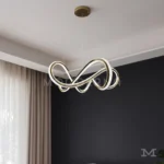 Luminaria Farella Gold instalada en sala moderna. Su diseño entrelazado crea un efecto visual sofisticado y dinámico que aporta personalidad al ambiente. Ideal para salas amplias de estilo contemporáneo.