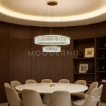 Luminaria Deline Gold instalada sobre comedor moderno. Su luz LED blanca cálida se distribuye uniformemente entre los aros, generando una iluminación envolvente y elegante. Ideal para ambientes amplios y contemporáneos.