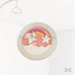 Luminaria Pink Cute sobre fondo blanco con diseño decorativo infantil en tonos rosados y detalle de arcoíris con nubes. Fabricada en aluminio y cristal, incorpora luz LED de bajo consumo, ideal para habitaciones de niñas o espacios temáticos suaves y alegres.