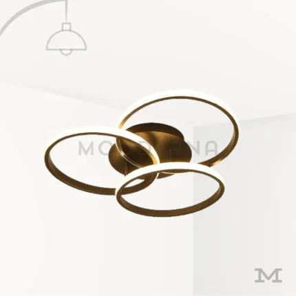 Luminaria Selene Black en fondo blanco con diseño de tres aros entrelazados en acabado negro mate con detalles dorados. Su luz LED integrada aporta un estilo moderno, decorativo y elegante ideal para salas, estudios y dormitorios contemporáneos.