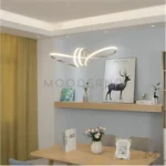 Segunda vista de Madison Platinum en comedor, mostrando cómo su estructura curva distribuye la luz de forma uniforme, aportando presencia sin saturar el espacio.