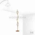 Livana Gold en fondo blanco mostrando su estructura escultórica con líneas curvas entrelazadas en acabado dorado satinado, una pieza decorativa que destaca por su diseño elegante y artístico.