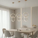 Lorea One Gold instalada en comedor, aportando una iluminación focal cálida y elegante que realza la mesa y complementa ambientes modernos y contemporáneos.