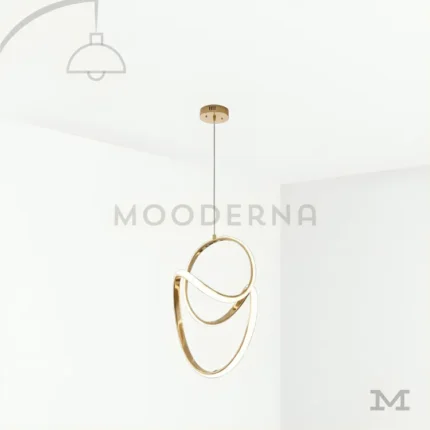 Vela One Gold en fondo blanco, mostrando su diseño colgante circular con acabado dorado satinado y luz LED integrada, ideal para espacios modernos y elegantes.