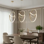 Vela One Gold instalada en comedor moderno, aportando iluminación puntual y decorativa que realza la mesa con un estilo elegante y sofisticado.