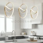 Vela One Gold instalada en comedor contemporáneo, funcionando como punto focal visual gracias a su diseño circular y acabado dorado satinado.