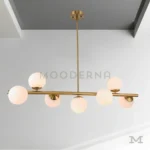 Detalle cercano de Adele Gold, mostrando las esferas de vidrio y la estructura de aluminio con acabado dorado satinado.