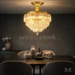 Pauline Gold Crystal instalada en comedor, resaltando la mesa central con una iluminación cálida y sofisticada.