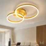 Katianna Gold en sala desde otro ángulo, resaltando su diseño dorado y presencia decorativa.