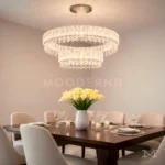 Danielle Platinum Crystal instalada en comedor, iluminando la mesa principal con un diseño brillante y decorativo.