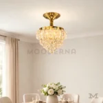 Matilda Gold Crystal en segunda toma de sala, resaltando el brillo de los cristales y el acabado dorado.