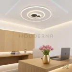 Lámpara LED de techo Esther Mix con diseño circular iluminando una oficina moderna.