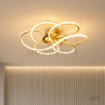 Detalle de los aros LED entrelazados y acabado dorado satinado de Lota Gold