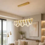 Lámpara colgante LED dorada Ariel Gold con aros luminosos en sala moderna