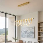 Lámpara LED colgante Ariel Gold con aros dorados y suspensión ajustable en comedor