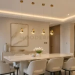 Cuatro lámparas colgantes Candela Gold doradas sobre mesa de comedor moderno