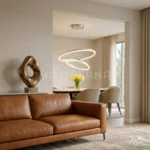 Lámpara LED Billy Platinum de dos aros iluminando una sala moderna con sofá beige y ventanales.