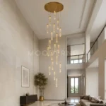 Lámpara colgante Sienna Gold de 19 luces doradas iluminando una sala moderna de doble altura.
