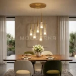 Lámpara colgante Mercy Gold de seis luces doradas decorando una sala moderna con iluminación cálida.
