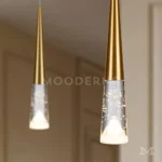 Detalle de lámpara Mercy Gold con luces colgantes doradas y difusores transparentes de efecto burbuja.