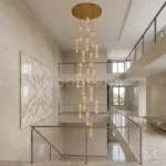 Lámpara Sienna Gold de 19 luces LED colgantes sobre una escalera moderna de doble altura.