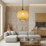Lámpara colgante Marlene de ratán instalada en sala moderna con sofá de tonos neutros